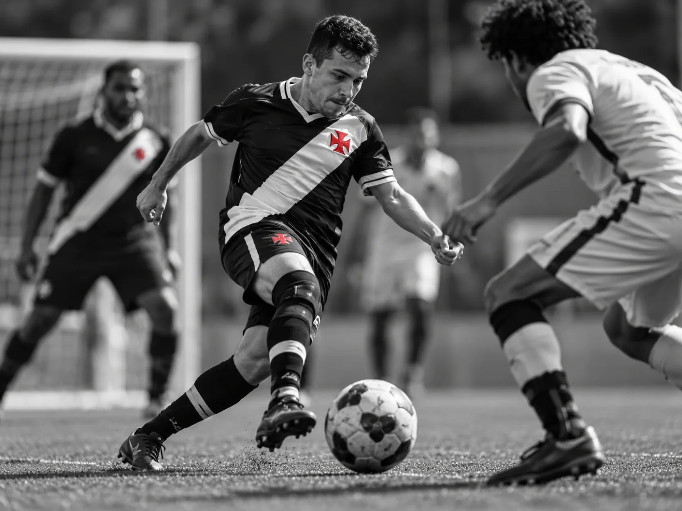 Jogador com uniforme vascaíno conduz a bola em partida de futebol de 7