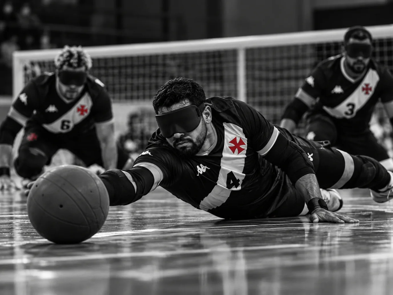 Atleta vendado se lança ao chão para defender a bola no goalball